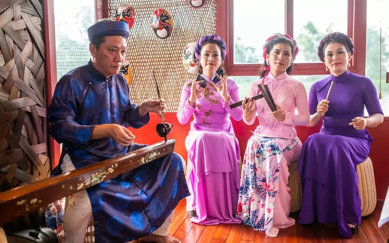 Musicians in traditional ao dai perform Hue folk songs aboard a boat on the Perfume River.