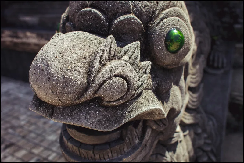 Close-up of a stone guardian statue with green glass eyes at Khai Dinh Royal Tomb in Hue.
