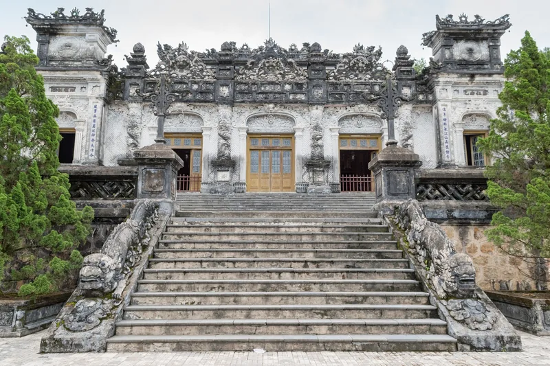 Ornate stone facade and stairway of Khai Dinh Tomb in Hue, decorated with intricate carvings and mosaics.