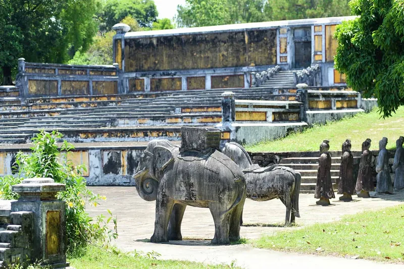 Stone statues of elephants, horses, and mandarins line the terraced courtyard of Gia Long's tomb near Hue.