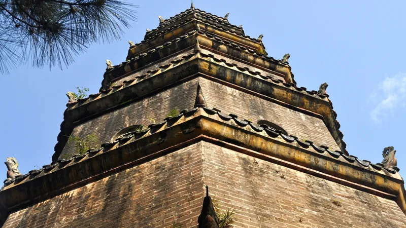 Low-angle view of the weathered brick tiers of Phuoc Duyen Tower at Thien Mu Pagoda in Hue.